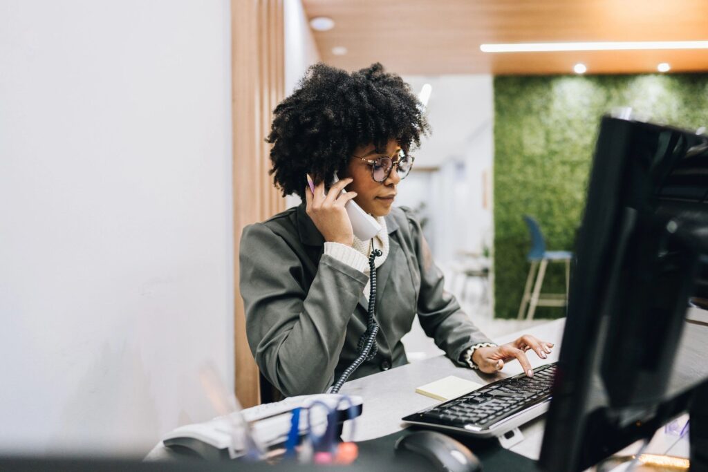 Receptionist young woman talking on landline phone in the medical clinic